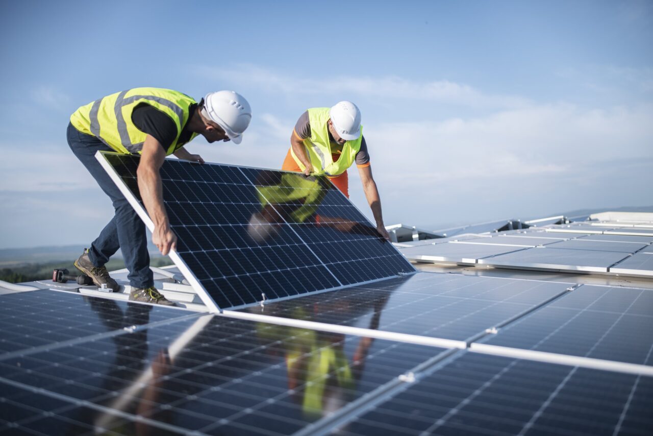 Two engineers installing solar panels on roof. Two engineers installing solar panels on roof.